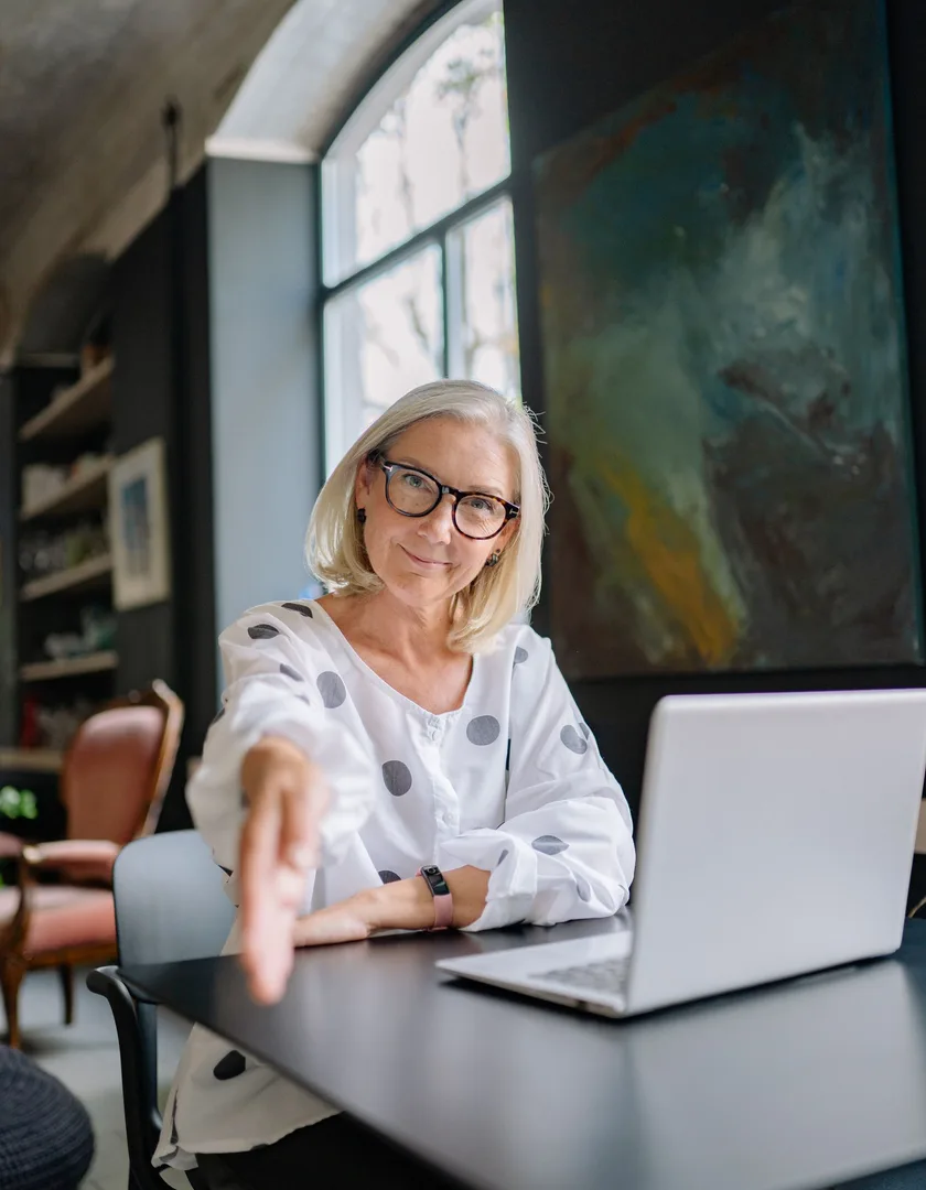 Advogada sorrindo e cumprimentando cliente no escritório